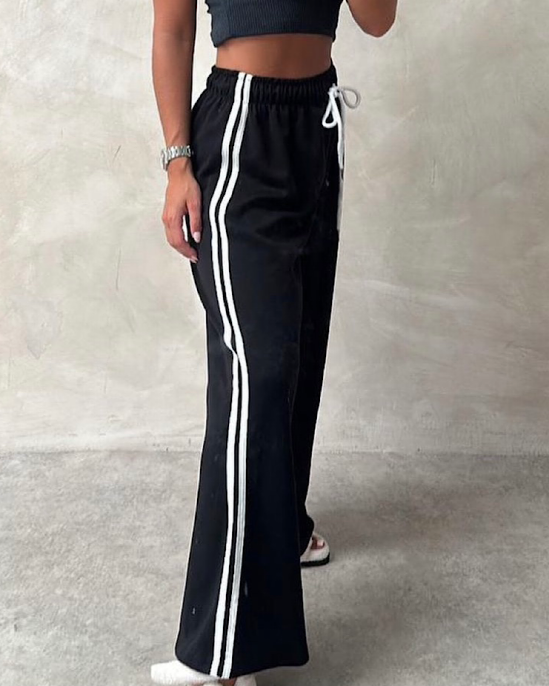 Czarne spodnie dresowe z białymi paskami po bokach